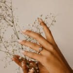 Embrace Ring with Flowers Embrace - Platinum with a diamond on a hand.